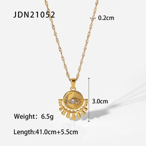 Collier en acier doré avec pendentif étoile, lune et œil sur un fond blanc neutre