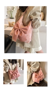 Detail of pink suede tote bag with large bow and silver chain strap on model