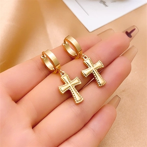 Detailed view of gold stainless steel huggie hoop earrings with cross pendants on silk