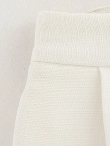 Macro detail of beige cotton-linen fabric texture and side seam stitching on the vest