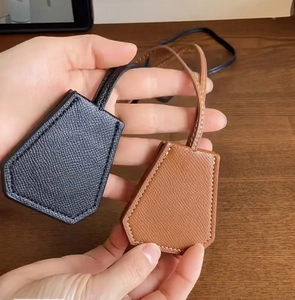 Detail of premium grain leather clochette hat clips in black and caramel brown colors