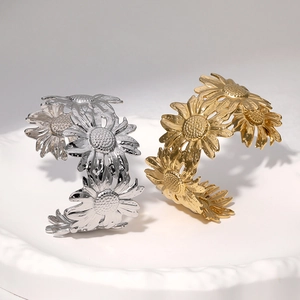 Close-up of daisy sunflower open bracelets in polished gold and silver steel finish