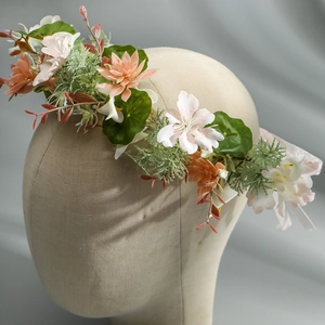 Close-up of artificial floral wreath headband with pink, orange and white silk flowers