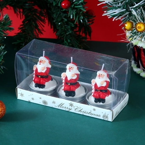 Three Santa Claus shaped candles in a Merry Christmas gift box with transparent lid