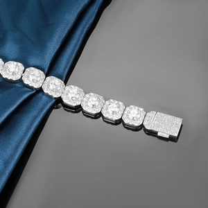 Macro shot of 12mm silver Cuban chain with square zircon stones on blue silk