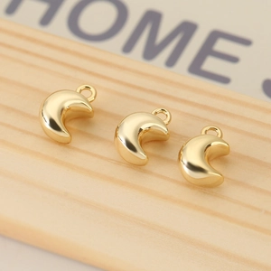 Macro shot of three polished gold-plated 3D moon charms for DIY jewelry accessories