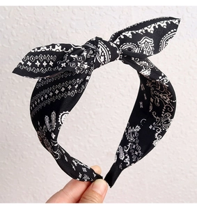 Detail of black paisley headband featuring bow knot design and soft cotton fabric texture