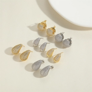 Detailed flat lay of cubic zirconia hoop earrings and water drop studs in gold and silver