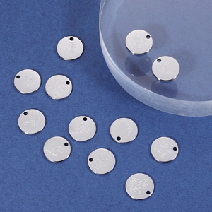 Detail of silver round stainless steel pendants with engraved birth flower designs