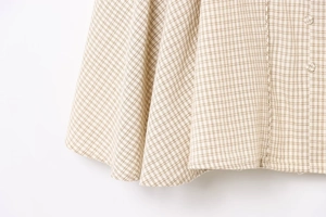 Detail shot of beige plaid cotton-linen fabric with decorative round button and texture