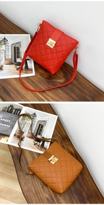 Detail of red and brown quilted crossbody bags with golden metal locks on wooden surface