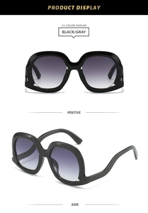 Front and side views of stylish oversized black sunglasses with gray gradient lenses