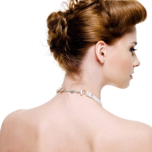 Magnetic heart clasp on a pearl and metal necklace worn on a model's neck