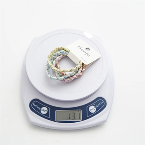 Detailed view of candy color twisted hair ties set on a scale weighing 13.1 grams