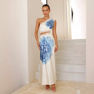 Détail de la robe en satin blanc avec imprimé floral bleu et dentelle blanche ajourée