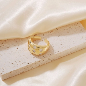 Detailed shot of golden wide open ring featuring sparkling clear cubic zirconia stones