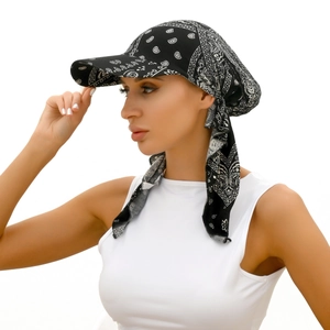 Detail showing black and white paisley print headscarf with ties on a model