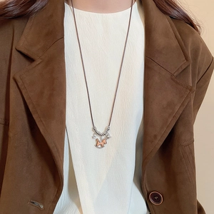 Detail of wooden rocking horse pendant necklace with silver stars on a brown cord chain