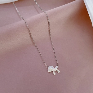 Macro detail of minimalist silver horse pendant on a fine link chain jewelry piece