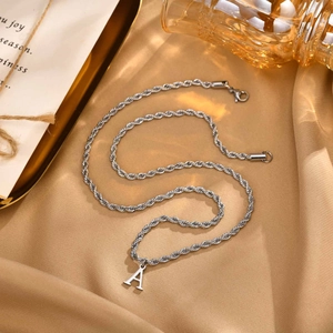 Silver stainless steel rope chain with capital letter A pendant on beige satin background
