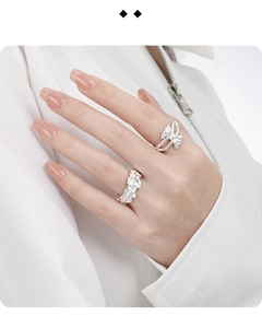Close-up of S925 sterling silver hollow bow ring and textured band on model hands
