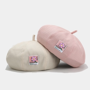 Knitted beret hats for women in pink and cream beige with floral patch decoration