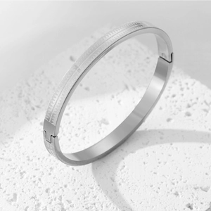 Eleganter silberner Edelstahl-Armreif mit geometrischer Punkttextur auf Steinsockel