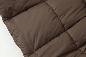 Vue détaillée de la texture matelassée marron foncé avec des coutures rembourrées