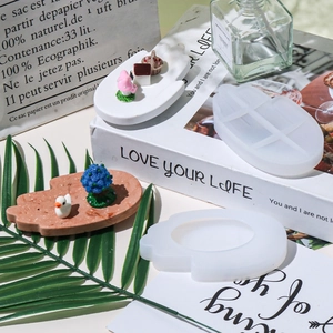 Detail of palm and flower silicone molds with finished plaster hand tray crafts