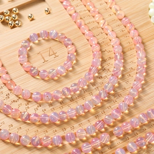 Detailed view of iridescent purple beads and gold accents on a wooden measurement board