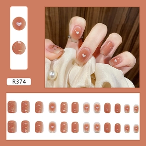 Short blush pink press-on nails with heart patterns and gold foil accents, 24pc set