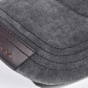 Macro view of washed cotton fabric and brown leather patch on a grey baseball cap