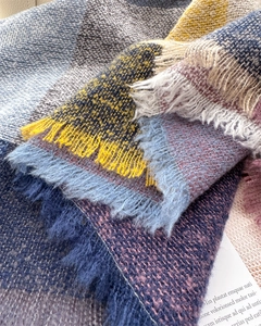 Macro shot of colorful plaid scarf with soft brushed texture and fringe details