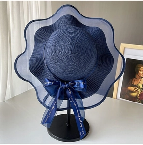 Detail of navy blue straw hat with wavy mesh brim and love you forever ribbon