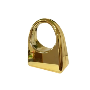 Modern gold acrylic evening clutch with a polished mirror finish and geometric handle
