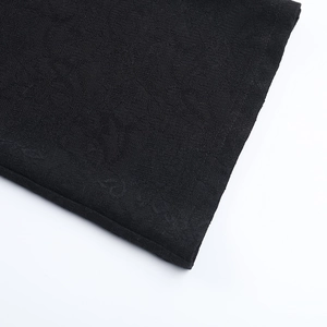 Dettaglio ravvicinato del tessuto in pizzo nero con trama a maglia per tute da donna