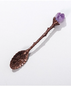 Detailed view of bronze-finished coffee spoon with natural amethyst stone on engraved handle