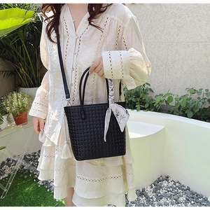 Detail of black woven bucket bag with silk scarf handle and detachable shoulder strap