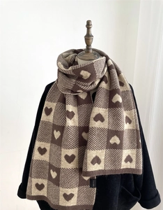 Detailed view of the thick knit texture and brown heart checkered pattern on the scarf