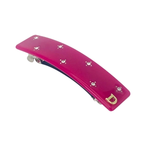 Dettaglio della molletta rosa con strass scintillanti e finitura dorata con lettera D