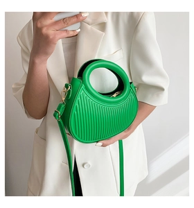 Close-up of bright green crescent bag featuring unique vertical embossed leather texture