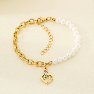 Detail of gold chain and pearl bracelet featuring a heart pendant with Mom engraving