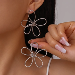 Minimalist silver metal hollow flower earrings with woven wire design on model
