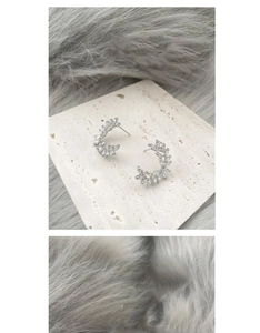 Detail showing elegant silver crescent wheat ear stud earrings with zircon inlay