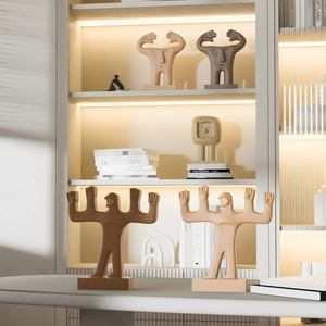 Figurines humaines abstraites modernes en couleurs Morandi sur une bibliothèque