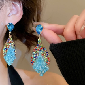 Close-up of bohemian tassel earrings with blue crystals and multi-color rhinestones