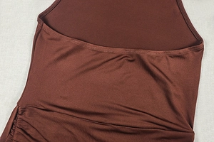 Détail de la robe moulante marron foncé montrant les fronces latérales et le tissu lisse