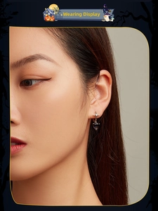 Gothic style silver heart earrings with purple stone shown on model for Halloween