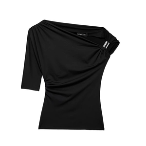 Detail of black one-shoulder top featuring an asymmetrical cut and silver metallic buckle
