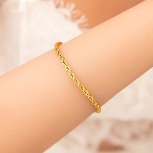 Close-up of golden twisted rope chain bracelet on wrist showing fine metal texture